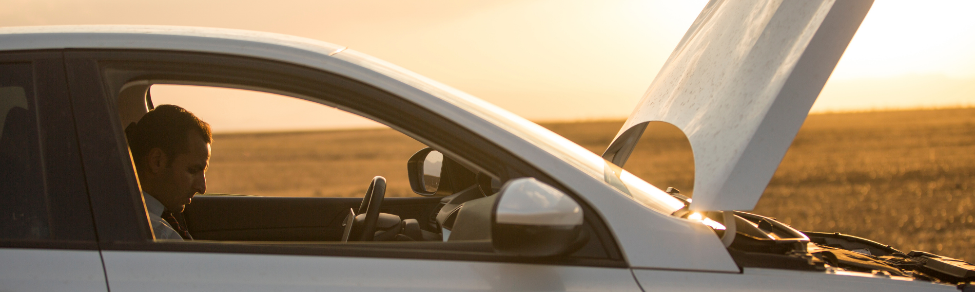 Motorist beside a vehicle receiving roadside assistance